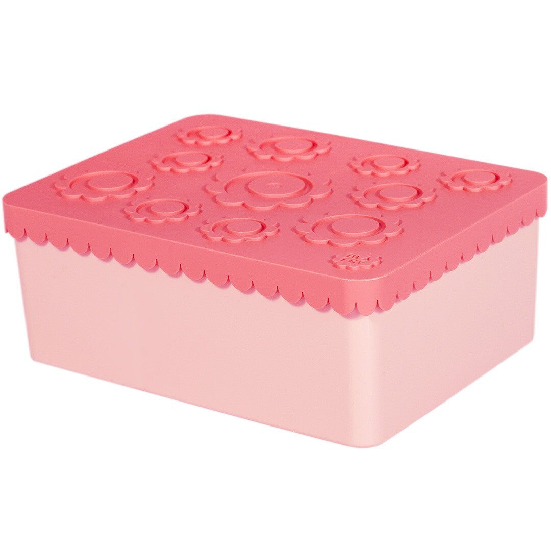 Blafre roze lunchbox van plastic met gebloemd patroon op de deksel.