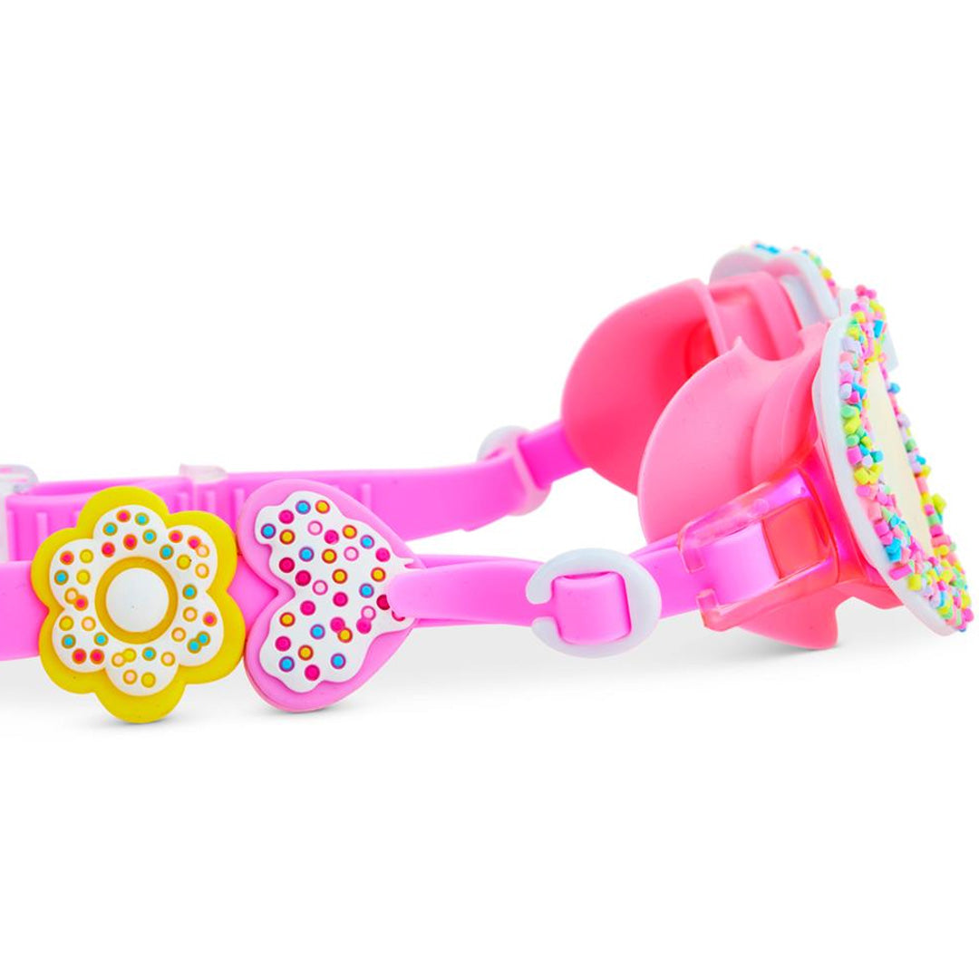 Zijkant van de bling2o kinderzwembril met roze band versierd met een hartje en een bloem met sprinkles.