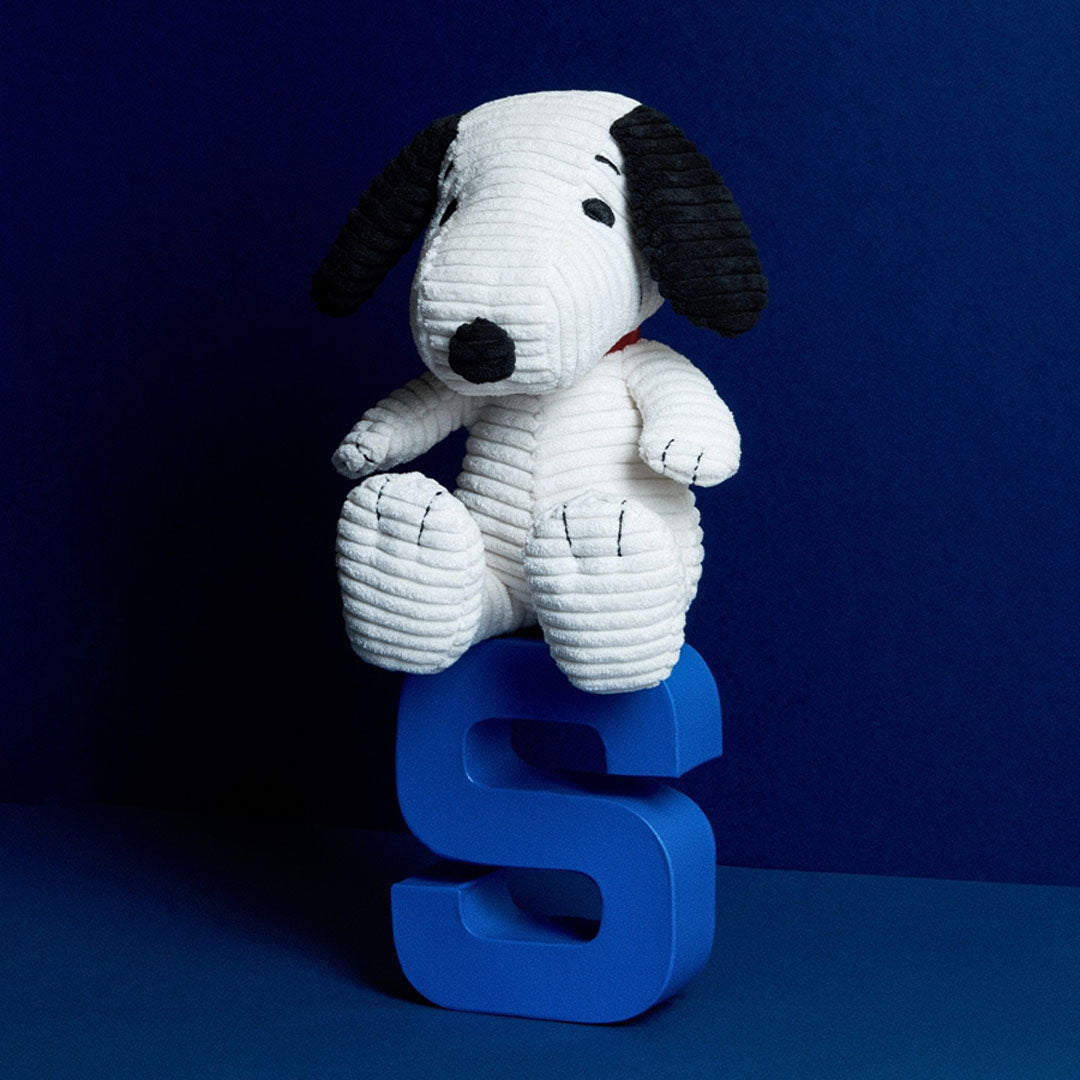 Bon Ton Toys Snoopy corduroy knuffelhond zittend op een grote blauwe letter S.