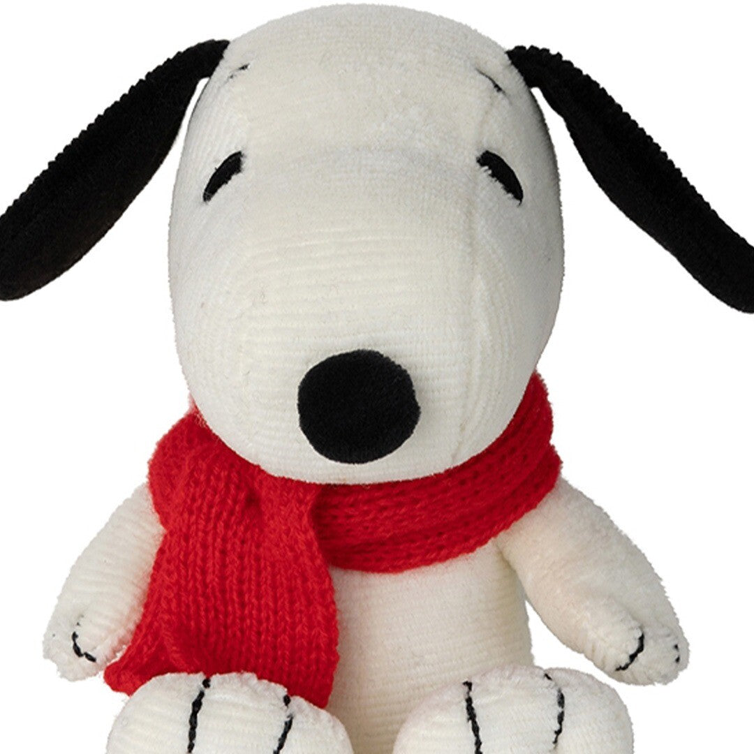 Detailopname van het gezicht van de pluchen knuffelhond Snoopy met rode sjaal.