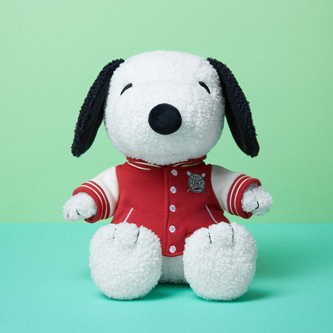 Bon ton toys pluchen knuffelhond Snoopy met rode sportjas, van voren gezien op een groene achtergrond.
