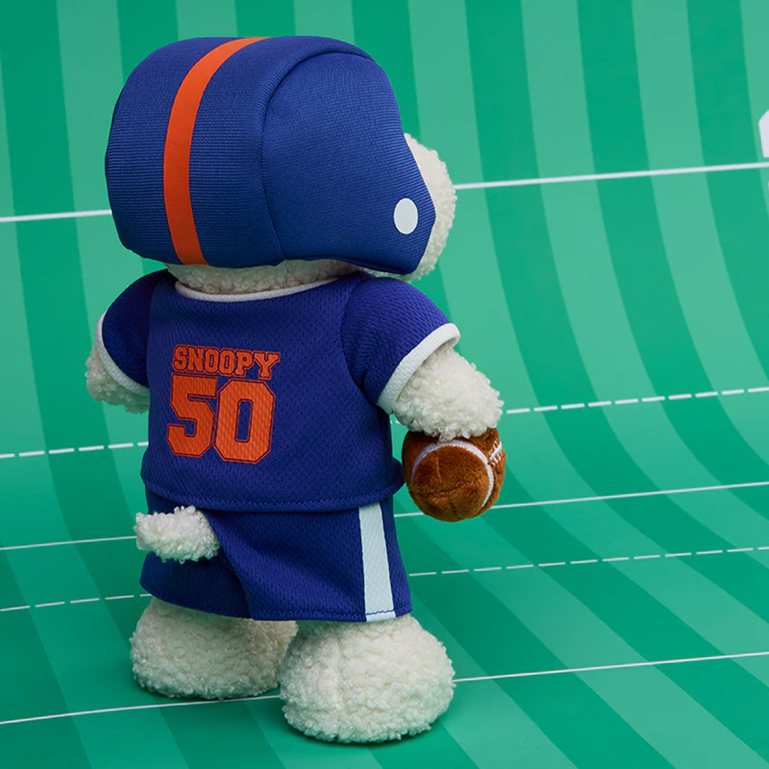 Achterkant van de pluchen knuffelhond Snoopy met 'SNOOPY 50' op het blauwe American football shirt.