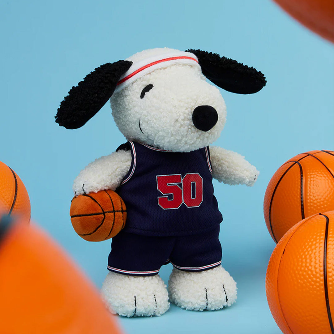 Bon ton toys pluchen knuffelhond Snoopy in basketbaltenue met nummer 50, met een basketbal op een blauwe achtergrond.