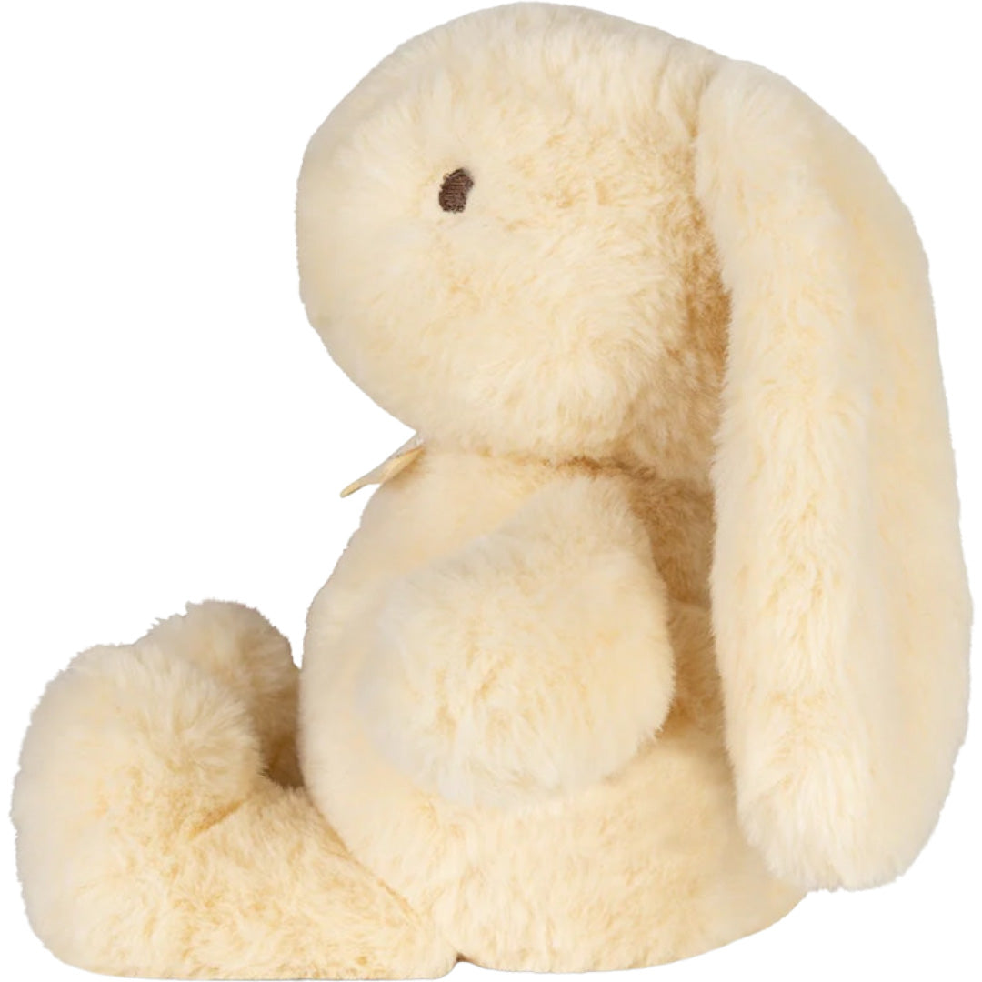 Geel pluchen knuffelkonijn met lange oren, zittend en van de zijkant gefotografeerd.