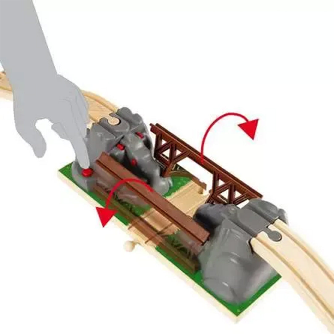 Een hand demonstreert hoe de Brio instortende brug openklapt door op de rode knop te drukken.