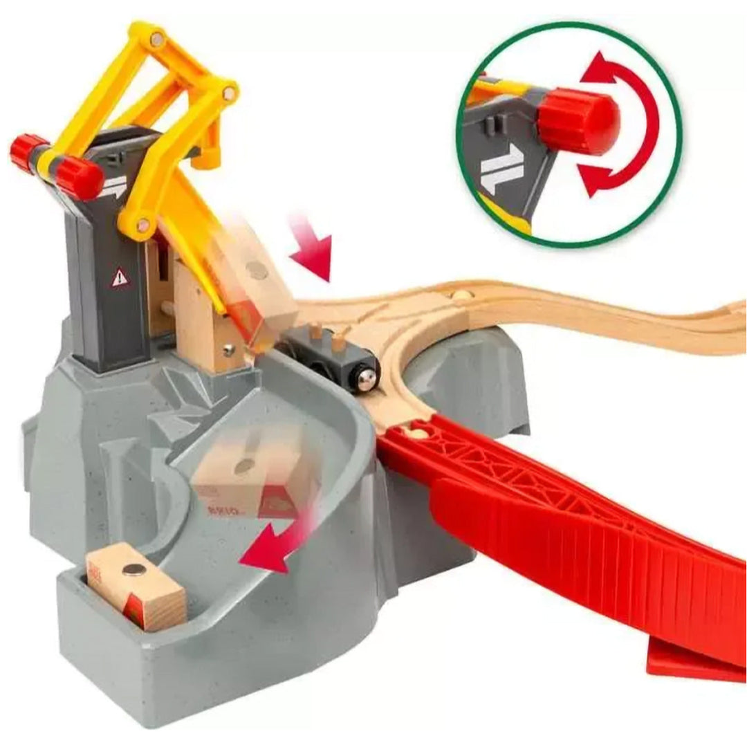 Detail van de Brio speelgoedtreinset met een geel laadstation dat houten blokken op de rails laat vallen.