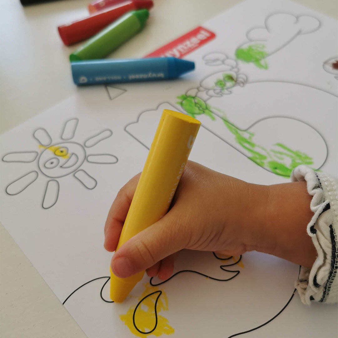 Een kinderhand kleurt met een geel Bruynzeel waskrijtje een zon op papier.