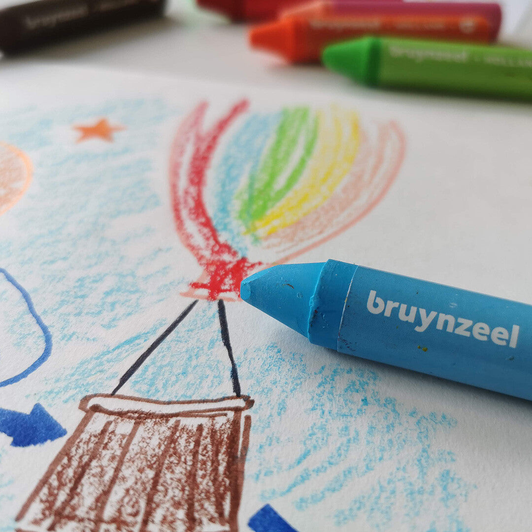 Een blauw Bruynzeel waskrijtje ligt op een tekening van een kleurrijke luchtballon.