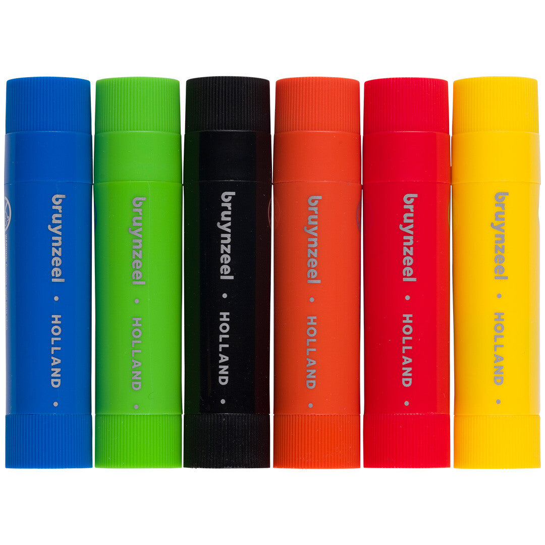 Zes Bruynzeel plakkaatverf stiften in basic kleuren, met de doppen erop.