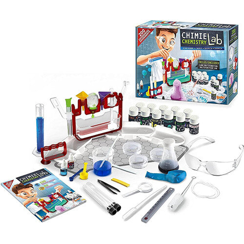Complete Buki scheikunde lab set met diverse bekerglazen, reageerbuizen, chemicaliën en veiligheidsbril, met de verpakking op de achtergrond.