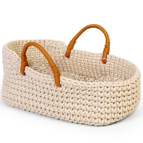 By Astrup gebreide poppenreiswieg met bruine handvatten en gebloemde binnenbekleding.