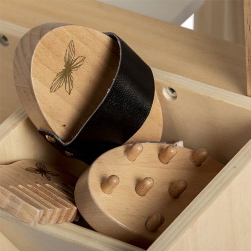 Twee houten borstels en een paardenkam van de paardenverzorgingsset in een houten kist.
