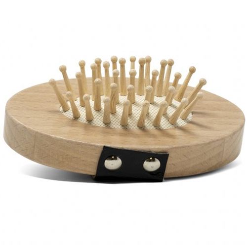 Detail van een ronde houten borstel met veel kleine houten pinnen en een zwarte band.