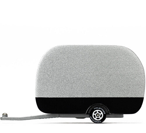 Zilverkleurige Candylab speelgoedcaravan Airstream met zwarte onderkant, van de zijkant gezien.