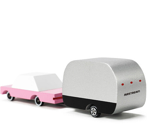 Candylab speelgoedcaravan Airstream in zilverkleur, gekoppeld aan een roze speelgoedauto.