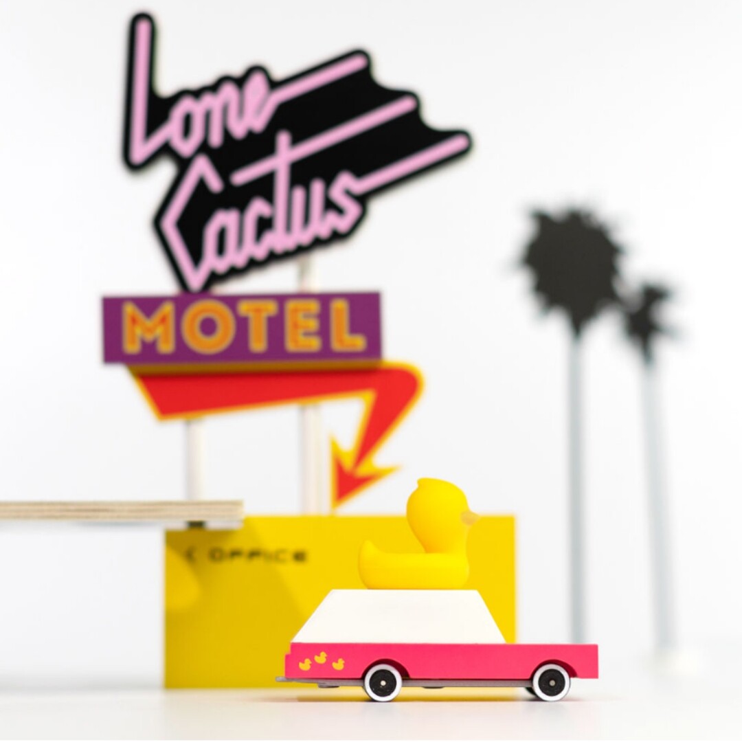 Candylab houten speelgoedauto met gele badeend in een speelscène met een motelbord.