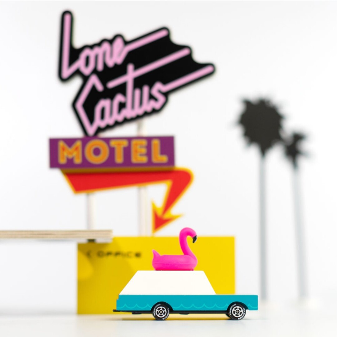 Candylab Candycar flamingo wagon voor een 'Lone Cactus Motel' bord en palmboomdecoratie.