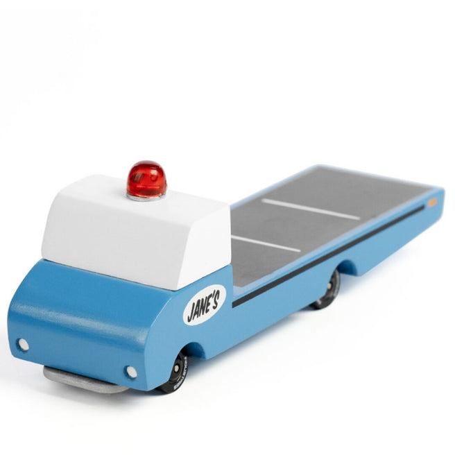 Candylab houten speelgoedvrachtauto in blauw met witte cabine en rood zwaailicht.