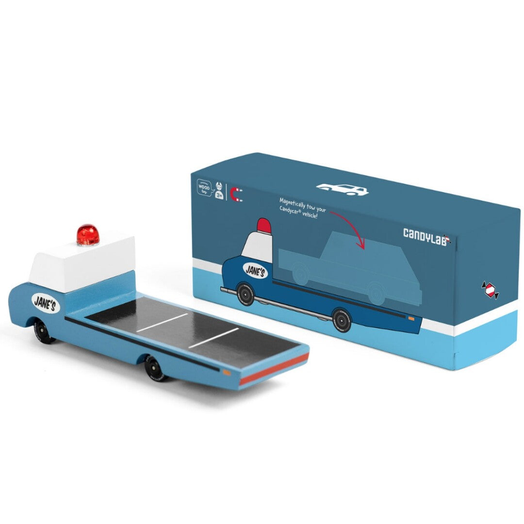 De Candylab blauwe houten speelgoedvrachtauto naast de bijbehorende productverpakking.