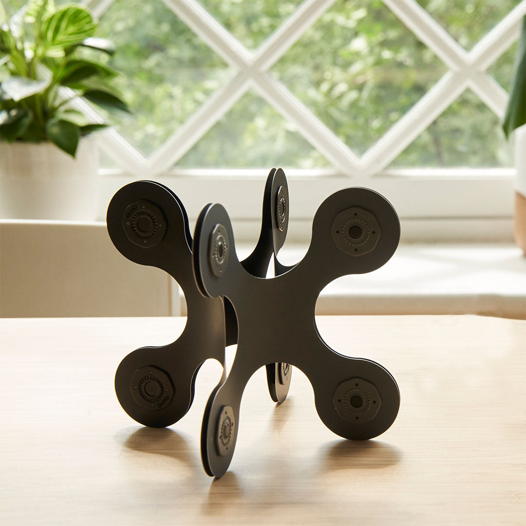 Clixo magnetische bouwset, een zwarte constructie van vierkante elementen op een houten tafel.