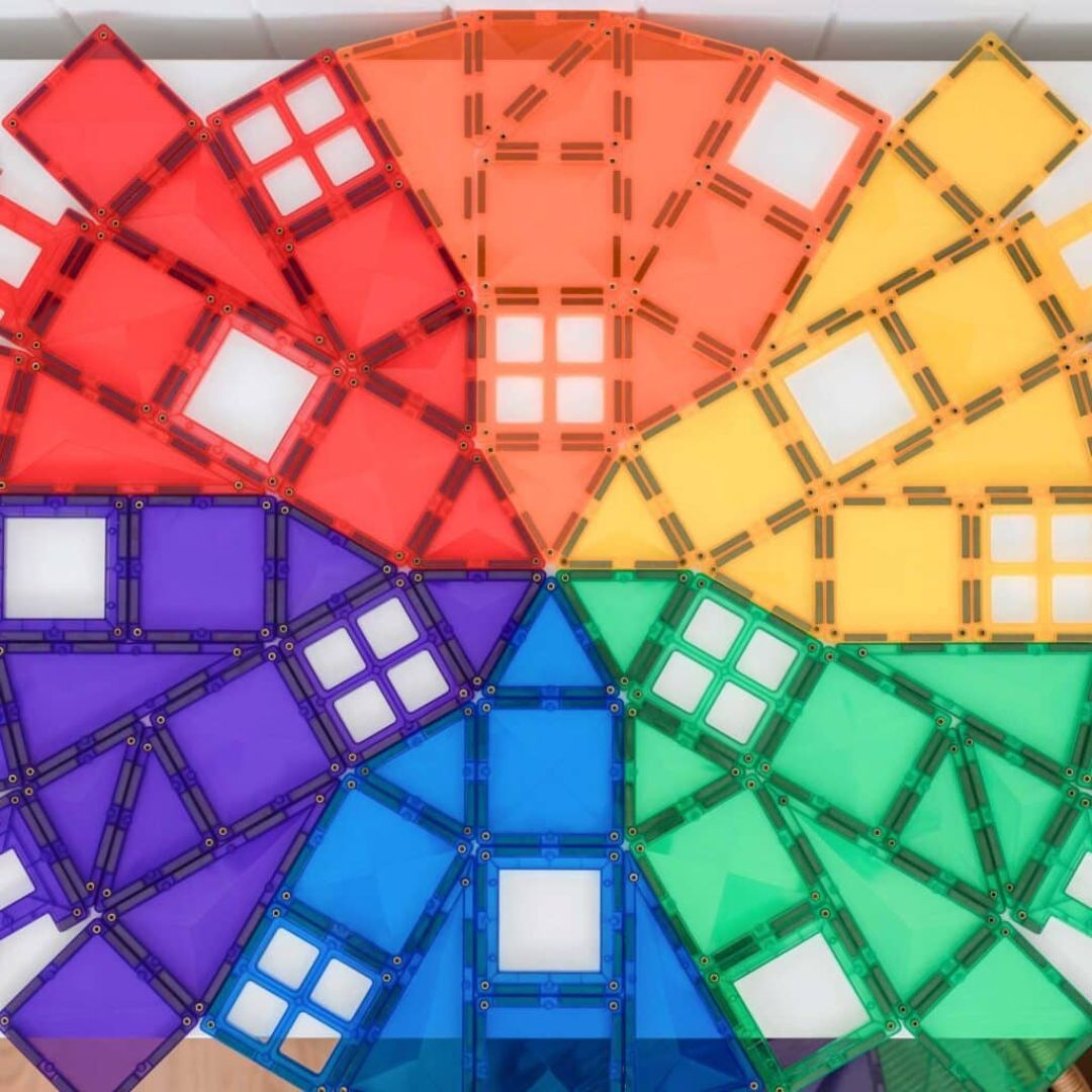 Een bovenaanzicht van een cirkelvormig regenboogpatroon gemaakt van Connetix magnetische tegels.