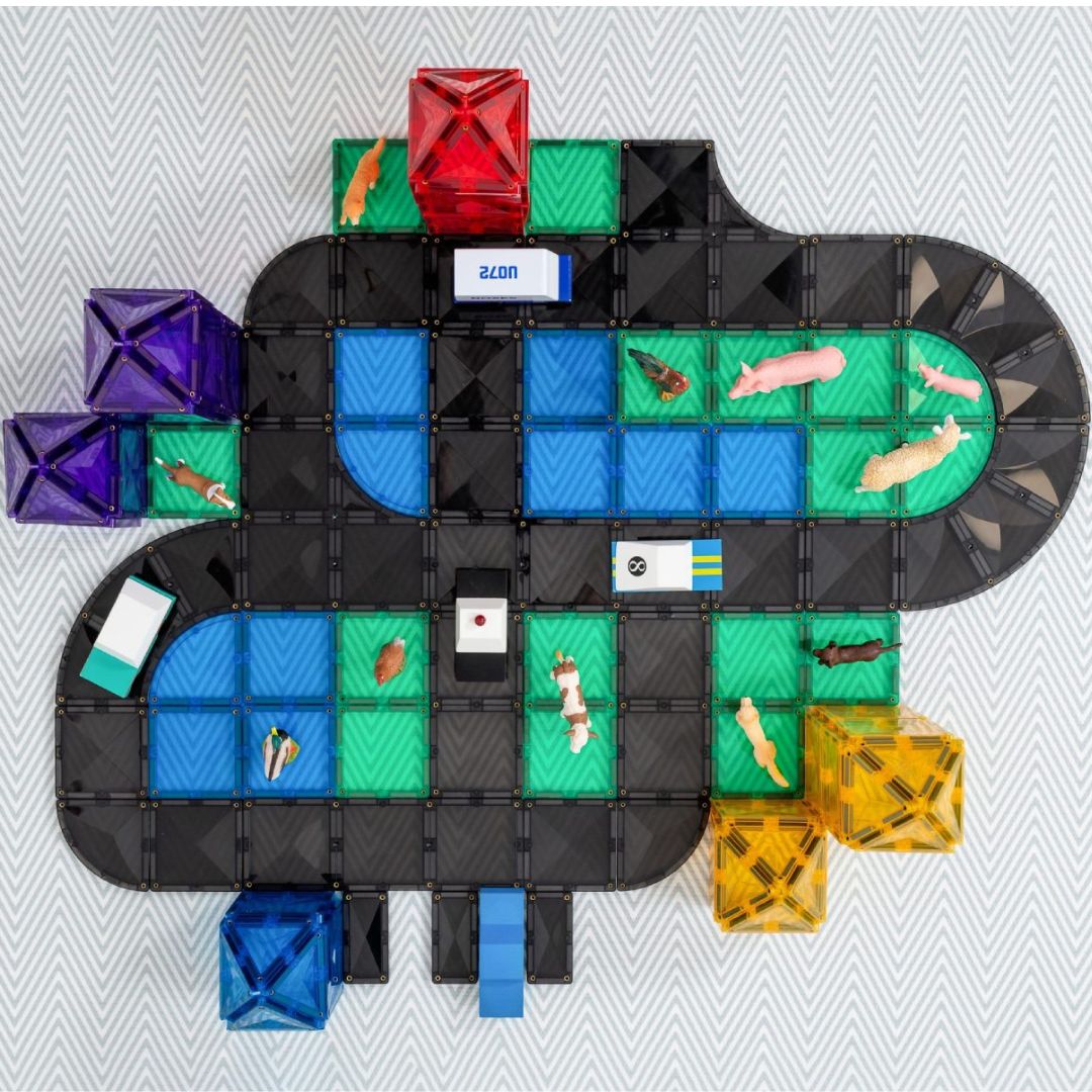 Een uitgebreide weg van zwarte en gekleurde Connetix magnetische tegels met kleine dierenfiguren eromheen.
