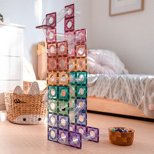 Een hoge Connetix magnetische tegels knikkerbaan in pastelkleuren, staand in een slaapkamer.