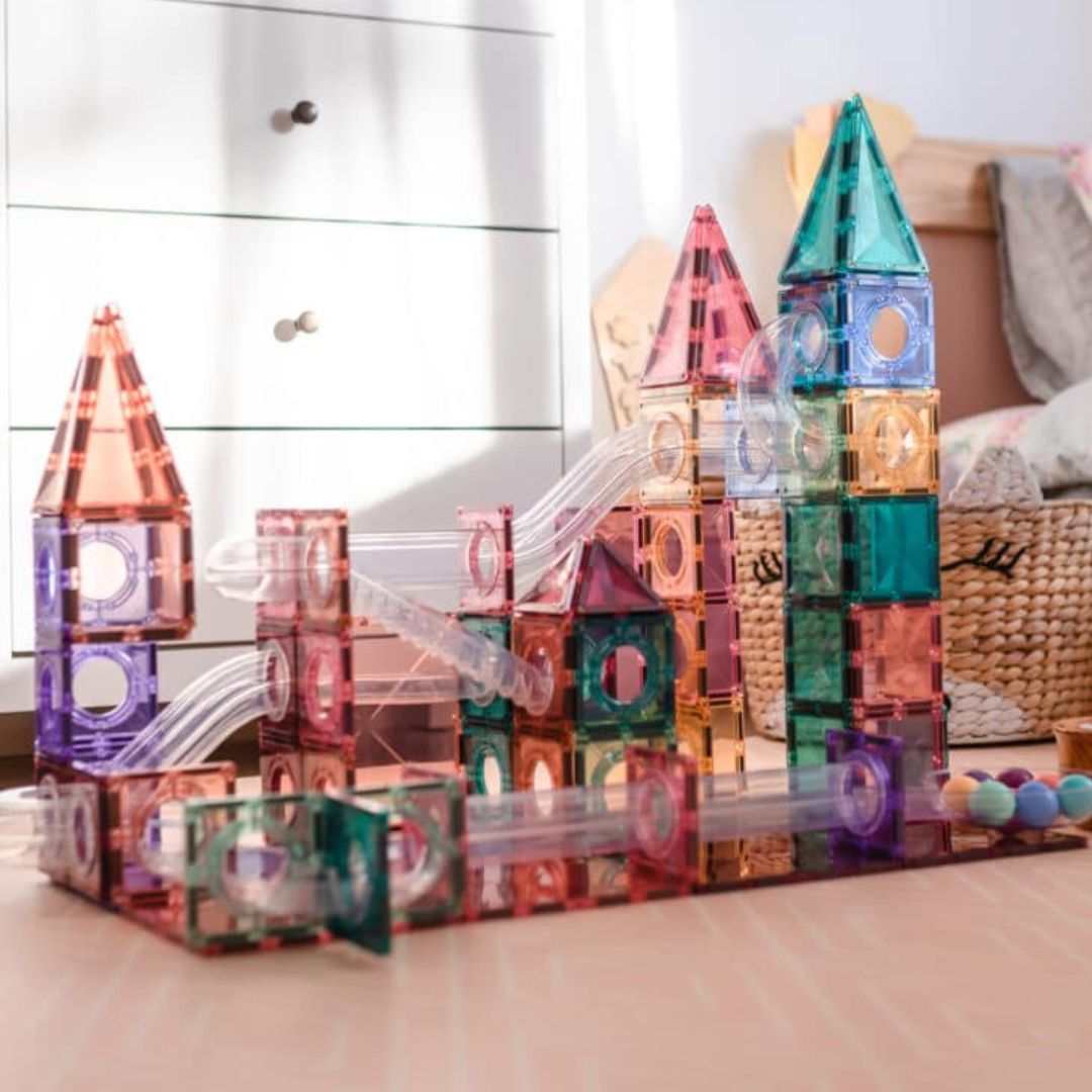 Een Connetix magnetische tegels knikkerbaan in pastelkleuren, gebouwd als een kasteel met transparante banen.