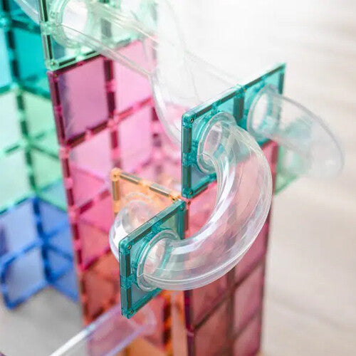 Detail van een transparante gebogen buis in de Connetix pastel knikkerbaan van magnetische tegels.