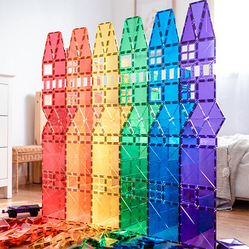 Een rij van hoge, regenboogkleurige gebouwen gemaakt van Connetix magnetische tegels.