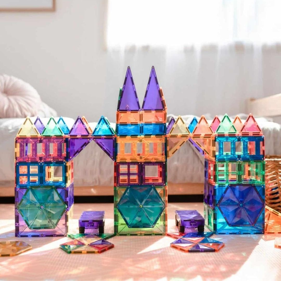 Een kleurrijk kasteel gebouwd van Connetix magnetische tegels met torens en bogen.