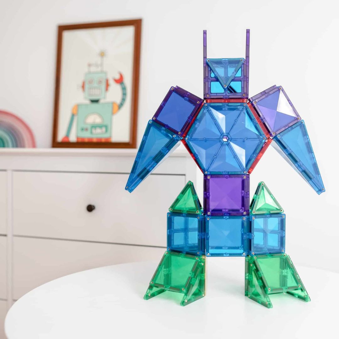 Een robotfiguur gemaakt van blauwe, paarse en groene Connetix magnetische tegels op een witte tafel.