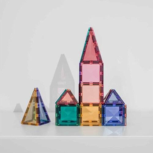 Meerdere huisjes en een toren gebouwd van Connetix magnetische tegels in pastelkleuren.