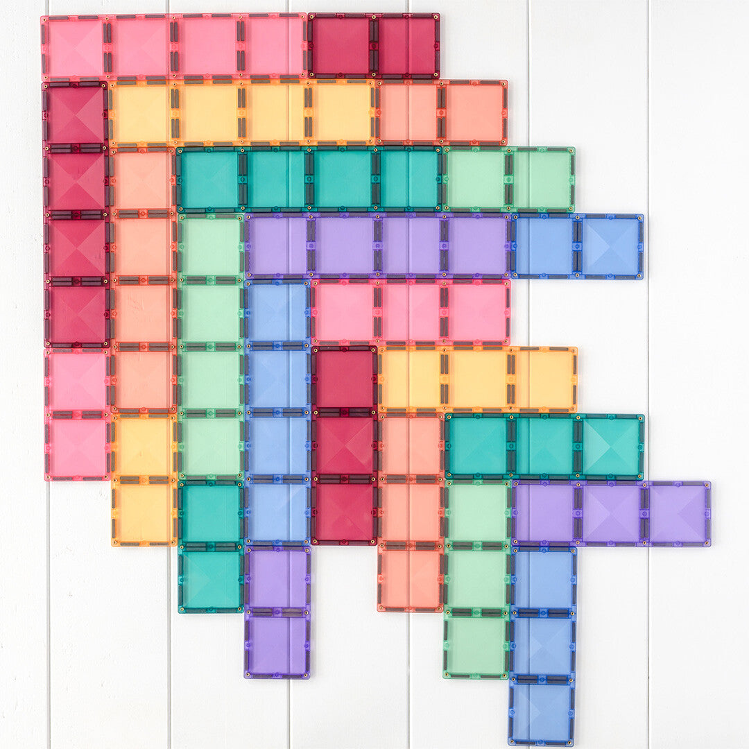 Een patroon van Connetix magnetische tegels in diverse pastelkleuren, plat op een witte ondergrond.