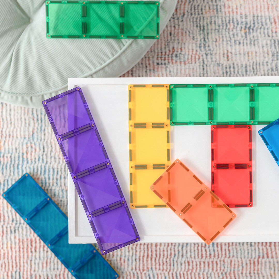 Bovenaanzicht van Connetix magnetische tegels in diverse regenboogkleuren, los en verbonden.