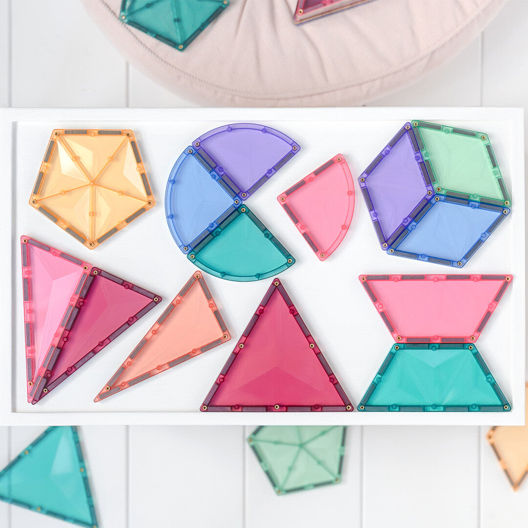 Een collectie Connetix pastel magnetische tegels in verschillende geometrische vormen op een witte ondergrond.