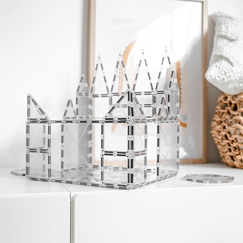 Een groot kasteel gebouwd met Connetix transparante magnetische tegels op een witte kast.
