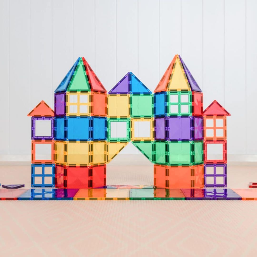 Een kleurrijk kasteel met torens en een boog, gemaakt van Connetix magnetische tegels.