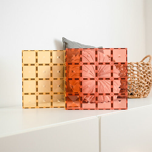 Twee Connetix pastel magnetische bouwplaten in lemon en peach staan rechtop op een witte ondergrond.
