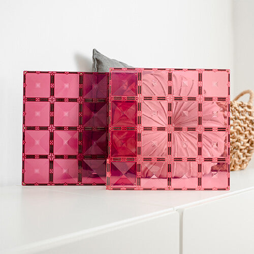 Twee Connetix magnetische bouwplaten in roze en bessenkleur staan rechtop tegen een witte achtergrond.