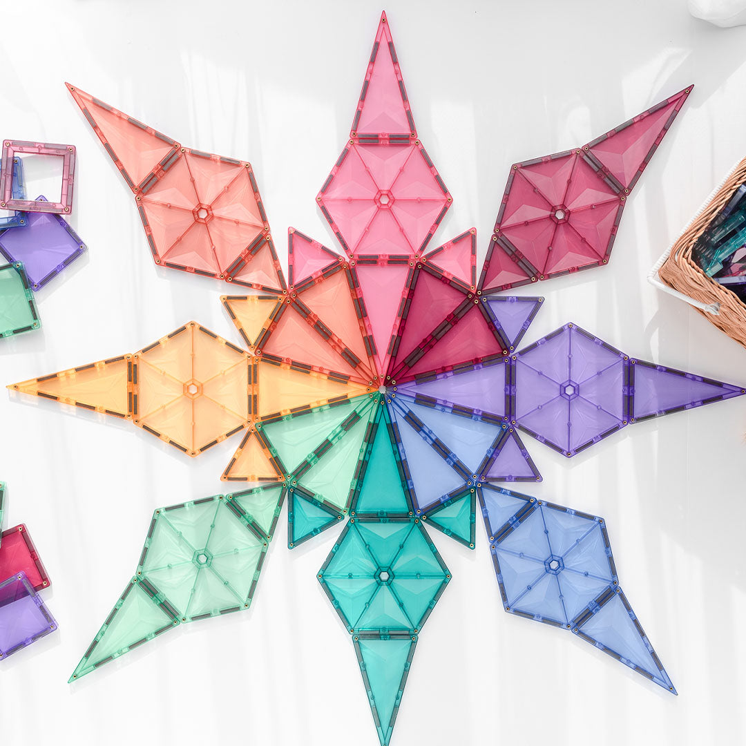 Een grote stervormige constructie van Connetix pastel magnetische tegels op een witte ondergrond.