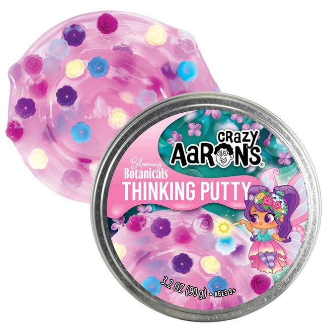 Crazy Aaron's Thinking Putty Blooming Botanicals, roze slijm met bloemvormpjes naast de metalen verpakking.