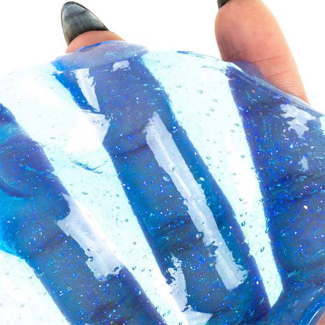 Handen die de blauwe, transparante Crazy Aaron's Thinking Putty uitrekken.