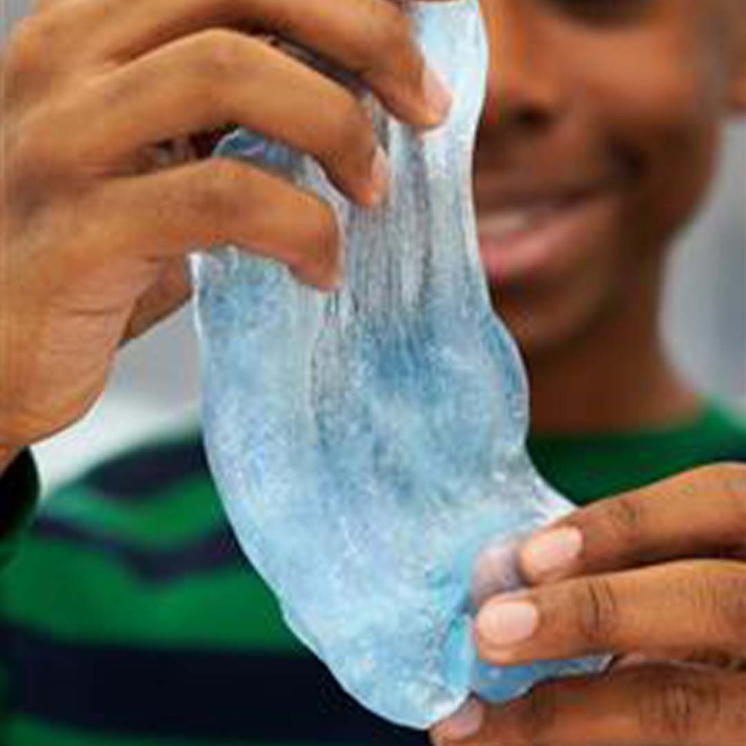 Een persoon die de blauwe, transparante Crazy Aaron's Thinking Putty uitrekt.