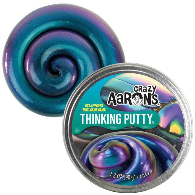 Crazy Aaron's Super Scarab Thinking Putty, een iriserende blauw-paarse kneedmassa, ligt naast de geopende verpakking.