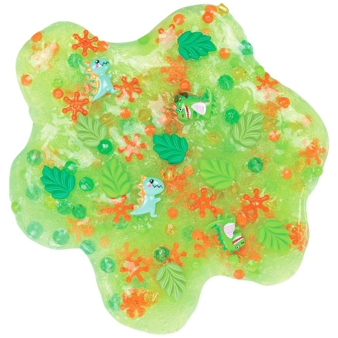 Detail van groen Crazy Aaron's Dino Dew slijm met dinosaurus- en bladvormige bedeltjes.