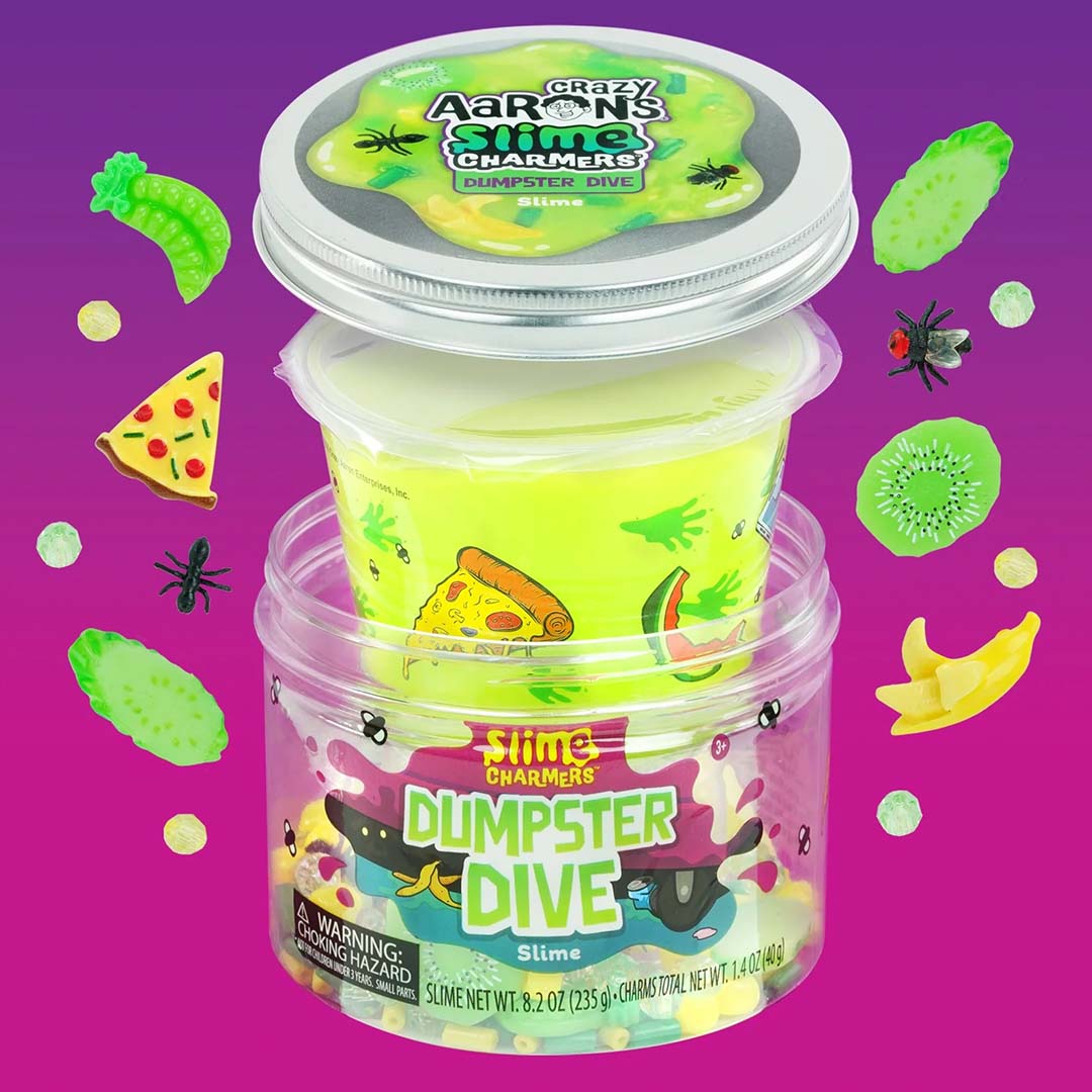 De open verpakking van Crazy Aaron's Slime Dumpster Dive met het slijm en diverse kleine speelgoedbedeltjes zoals een banaan, pizza, kiwi en insecten.
