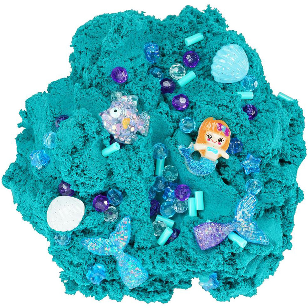 Detailopname van blauwe cloud slijm met diverse zeemeermin-bedeltjes en glimmende steentjes.