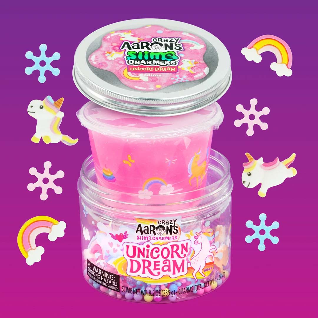 De Crazy Aaron's Unicorn Dream slijmset met de pot, het deksel, een binnenbakje slijm en losse eenhoorn-, regenboog- en sneeuwvlokbedeltjes.