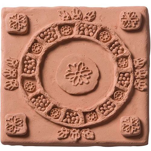 Een vierkante plaat terra-cotta luchtdrogende klei met ingedrukte decoratieve patronen.